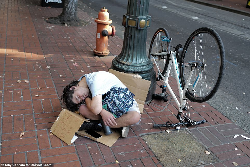 63571413-11322173-A_man_slumps_on_the_sidewalk_in_downtown_Portland_Oregon_Homeles-a-1_1666104...jpg